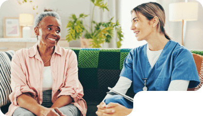 aide and senior woman smiling at each other