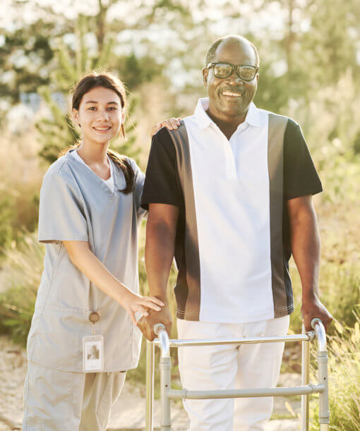 aide and senior man smiling