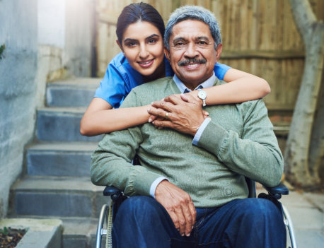 a young woman hugging an elderly man seated in a wheelchair