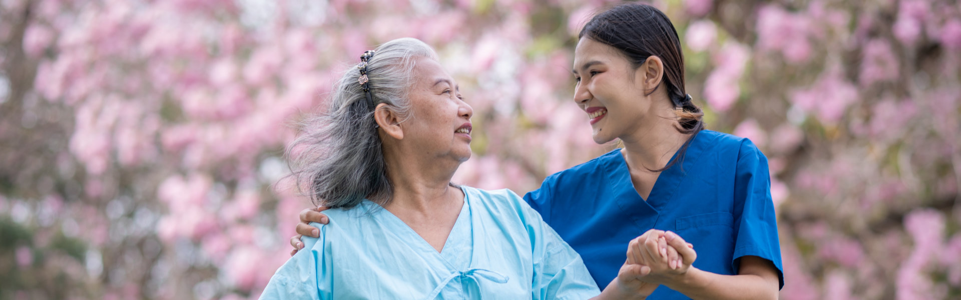 aide and senior woman smiling at each other