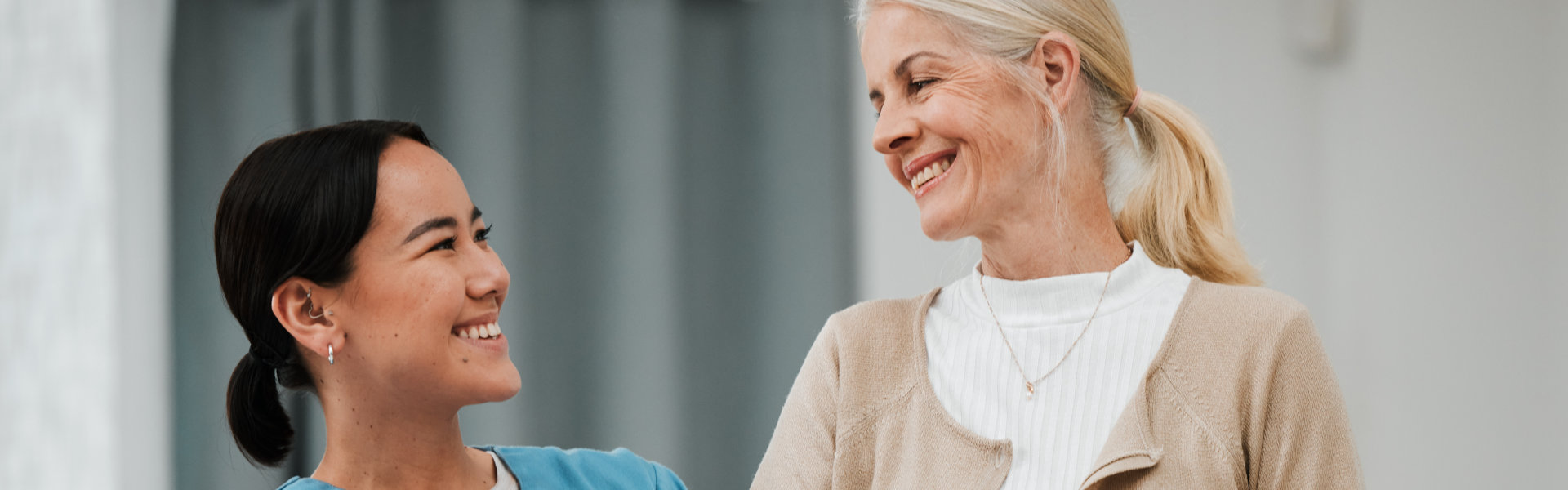aide and senior woman smiling at each other